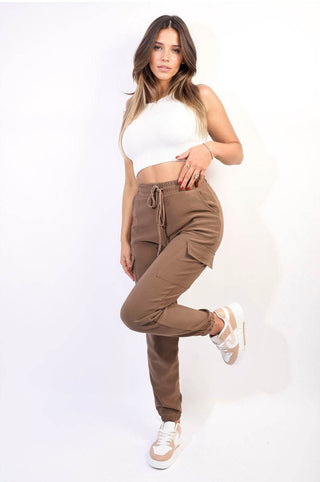 Cargo pocket trouser with drawstring in brown, styled with a white top and sneakers.