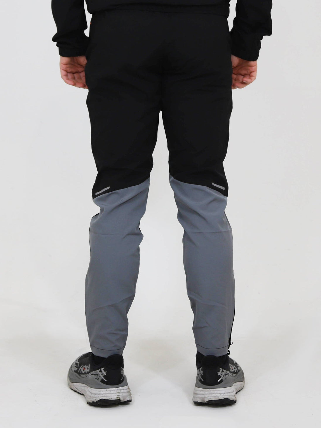 Back view of person wearing North Peak Glacier Track Pant in black and grey with athletic fit and reflective details