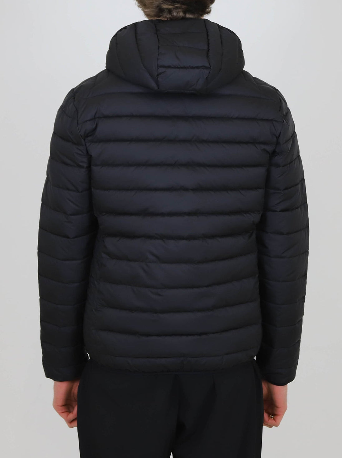 Back view of black Winter Steep Padded Jacket with hood and horizontal quilting on person