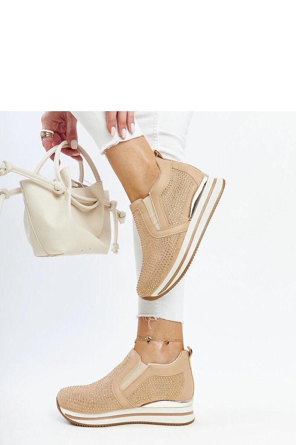 Brown wedge sneakers made of eco-leather with 4 cm heel, worn by a person in white jeans.