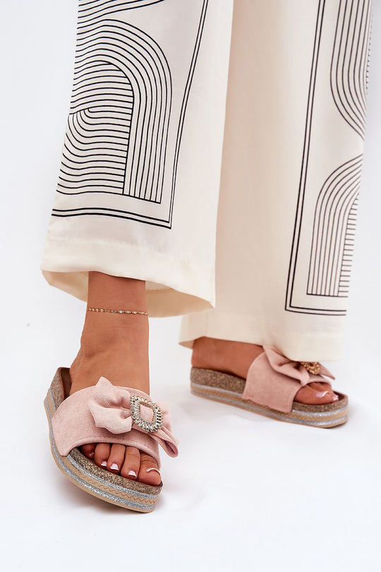 Suede flip-flops with a bow, brooch, and sequin platform.