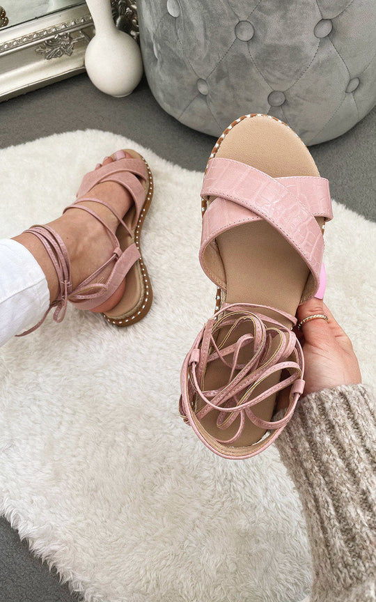 Deja Strappy Sandals in pink, featuring chic design and premium materials, displayed on a white rug.
